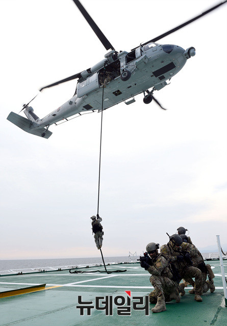 ▲ 특수전전단(UDT/SEAL) 대테러팀이 해군 UH-60 헬기에서 해경 제민12호(피랍 상선 모사) 함미 헬기갑판으로 공중 침투하고 있다.ⓒ해군