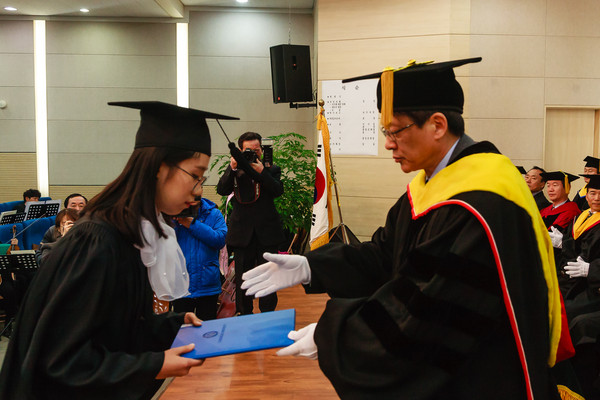 ▲ 김병기 청주대학교 총장이 19일 전기학위수여식에서 수석졸업자인 김혜원씨에게 학위증서를 수여하고 있다.ⓒ청주대학교