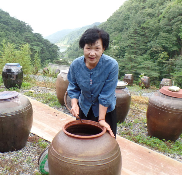 ▲ 담겨진 장을 살펴보고 있는 김영자씨ⓒ충주시