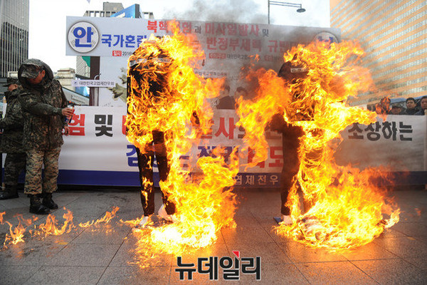▲ 대한민국고엽제전우회는 27일 서울 광화문 동화면세점 앞에서 '북핵실험과 미사일 발사 및 국가혼란을 획책하는 반정부세력을 규탄'하는 집회를 열면서 북한의 김정일, 김정은의 화형식 퍼포먼스를 행하고 있다. ⓒ정재훈 기자