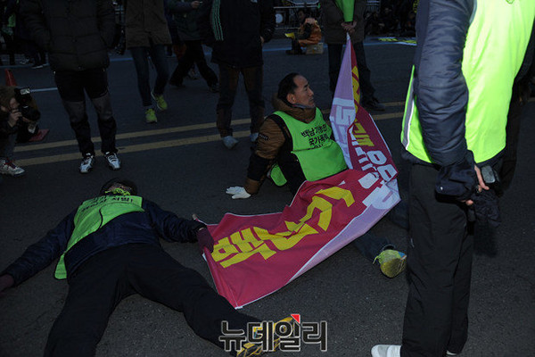 ▲ "경찰이 가두행진을 의도적으로 방해하고 있다"며 차량이 다니는 도로 위에 드러누운 시위대.  ⓒ뉴데일리정재훈 기자