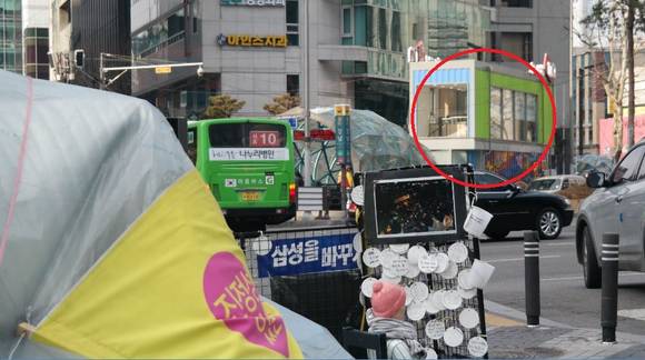 반올림 농성장 위로 보이는 붉은색 부분이 외국인들의 서울 관광을 돕는 '서초IQ센터'다. ⓒ최종희 기자.