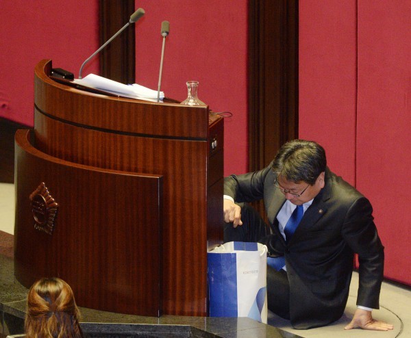 ▲ 테러방지법 저지를 위한 야당 의원들의 필리버스터가 사흘째 이어지고 있는 25일 밤 서울 여의도 국회 본회의장에서 강기정 의원이 무제한 토론을 하던 중 이석현 국회부의장의 격려 발언에 감정이 복받친 듯 발언대 뒤에 주저앉아 눈물을 흘리고 있다. ⓒ 뉴시스