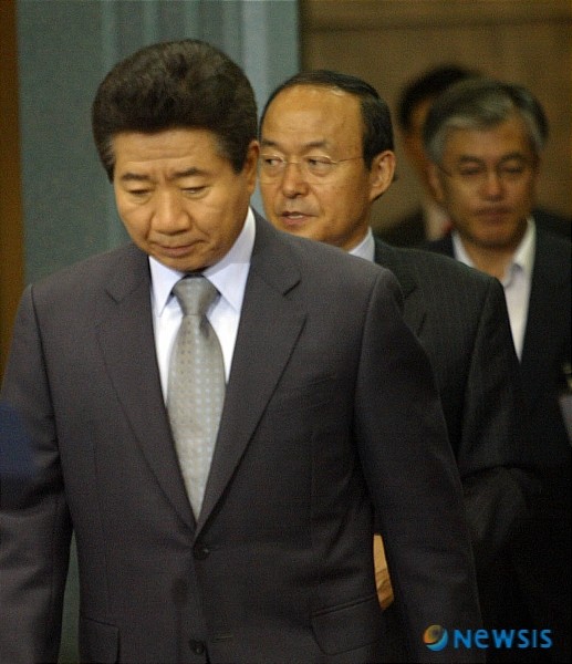 ▲ 무거운 표정의 노무현 대통령. 뒤쪽에 문재인 비서실장의 얼굴이 보인다. ⓒ뉴시스 사진DB