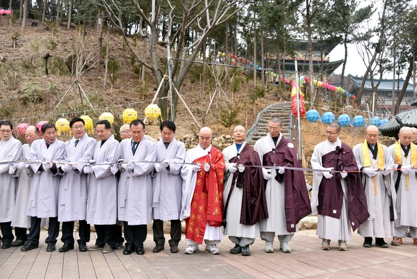 ▲ 삼광사 무원 주지(오른쪽 여섯번째)가 스님과 신도들이 참석한 가운데 힐링숲 개통식에서 테이프 커팅을 하고 있다. ⓒ삼광사