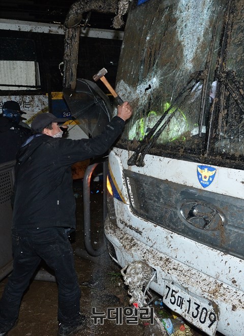 ▲ '민중총궐기' 폭력시위에 가담한 한 남성이 경찰버스에 쇠망치를 휘두르고 있다. ⓒ 뉴데일리 정상윤 기자