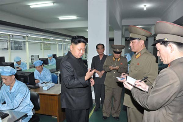 ▲ 북한제 스마트폰을 들여다보는 김정은. 북한은 자체적인 상품 개발보다는 '짝퉁' 상품을 만드는데 더 열성적이다. ⓒ뉴시스-로이터. 무단전재 및 재배포 금지.