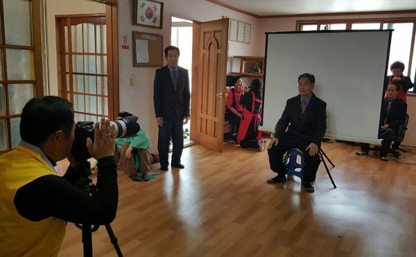 ▲ 단양에 정착한 귀농귀촌인들이 지역주민들에게 영정사진을 찍어 주고 있다ⓒ단양군