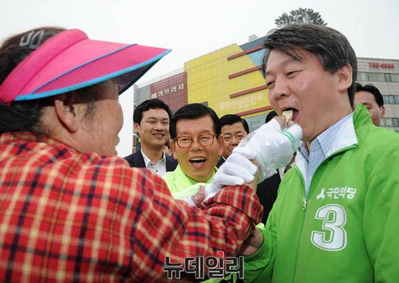 ▲ 국민의당 안철수 공동대표가 9일 오전 경기 성남시 중원구 모란시장에서 열린 성남지역 후보 합동지원유세 나선 가운데 한 상인이 권하는 엿을 받아먹고 있다. ⓒ 사진 뉴데일리DB