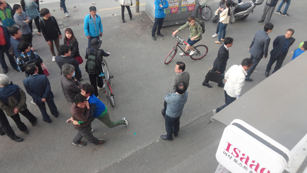 ▲ 문재인 대표의 연설 도중 , 물리적 충돌이 일어난 직후 기자가 2층에서 찍은 사진. 자주색 옷을 입은 남성을 더민주 당 관계자가 껴안으면서 황급히 말리고 있는 모습. ⓒ뉴데일리 임재섭 기자