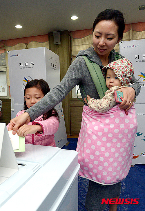 ▲ 13일 제20대 국회의원선거 투표일을 맞아 서울의 한 투표소에 한 유권자가 아이와 함께 방문했다. ⓒ 뉴시스