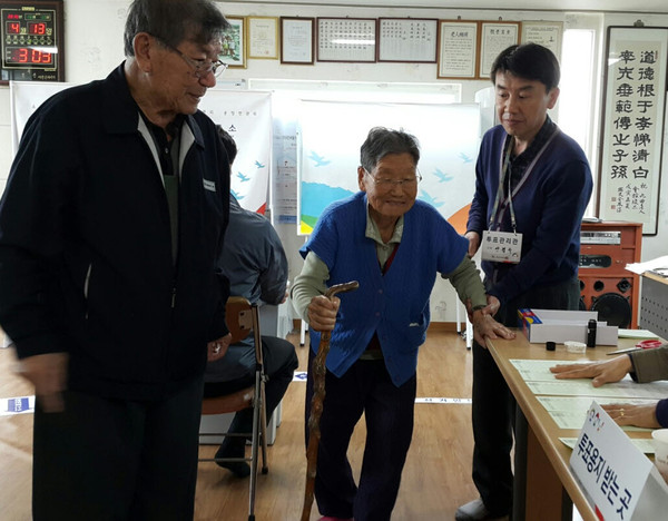 ▲ 박옥순 할머니가 투표를 마치고 직원들의 부축을 받으며 걸어 나오고 있다.ⓒ뉴데일리 독자 정홍철