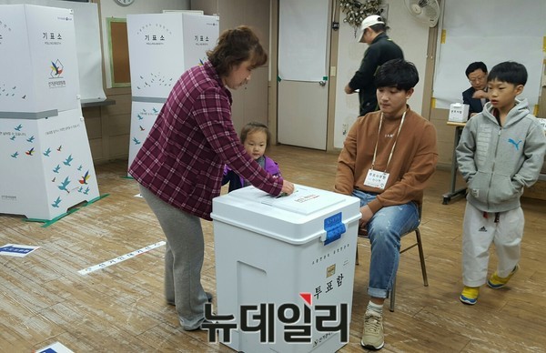 ▲ 투표소에서 여성이 어린이를 데리와 투표를 하고 있다.ⓒ뉴데일리