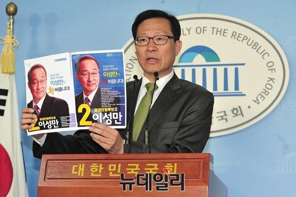 ▲ 국민의당 문병호 의원이 20일 국회에서 기자회견을 열고 인천 부평갑 당선무효소송 및 선거무효소송을 제기할 방침임을 밝히며 야권단일후보라는 명칭이 들어간 더불어민주당 이성만 후보의 벽보와 공보물을 들어보이고 있다. ⓒ뉴데일리 이종현 기자