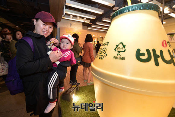 ▲ 빙그레 '옐로우 카페' 앞에서 한 고객이 바나나우유 열쇠고리를 손에 쥐고 웃고 있다. ⓒ정상윤 기자