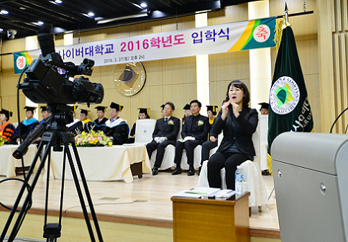 ▲ 지난 2월27일 경북 대구대 경산캠퍼스 성산홀에서 열린 '대구사이버대 2016학년도 입학식'에서 온라인 현장 중계와 함께 수화 통역 서비스가 제공되고 있다. ⓒ대구사이버대