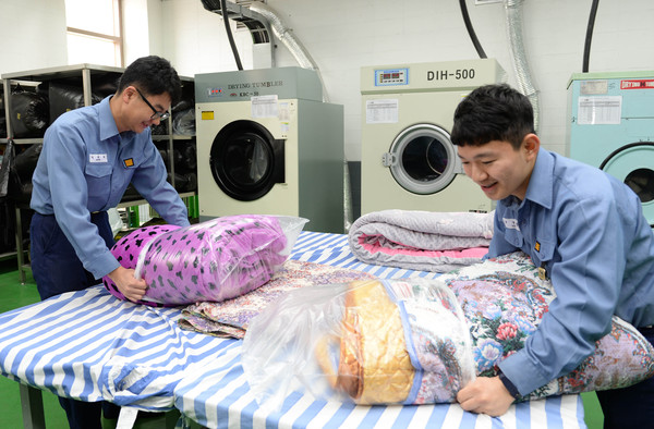 ▲ 보급지원대대 정대현 병장(사진 왼쪽)과 조현성 상병(사진 오른쪽)이 부대 세탁실에서 깨끗하게 세탁된 이불을 비닐로 포장하고 있다. ⓒ해군 제공