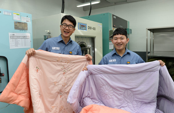 ▲ 보급지원대대 정대현 병장(사진 왼쪽)과 조현성 상병(사진 오른쪽)이 부대 세탁실에서 깨끗하게 세탁된 이불을 비닐로 포장하고 있다. ⓒ해군 제공