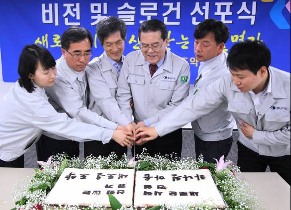 ▲ 이성희 경남기업 대표(왼쪽에서 네번째)와 직원들이 새로운 비전 선포를 기념해 축하떡을 자르고 있다.ⓒ경남기업