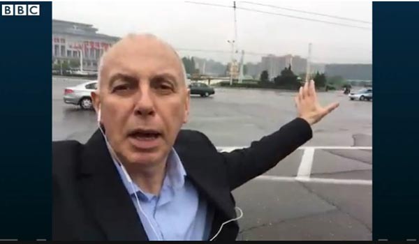 ▲ 크리스 에반스 英BBC 기자가 제7차 노동당 대회가 열리는 평양 4.25문화궁전을 가리키며 "지금 저 안에서 김정은과 노동당원들이 당 대회를 열고 있다"고 설명하는 모습. ⓒ英BBC 관련보도 화면캡쳐