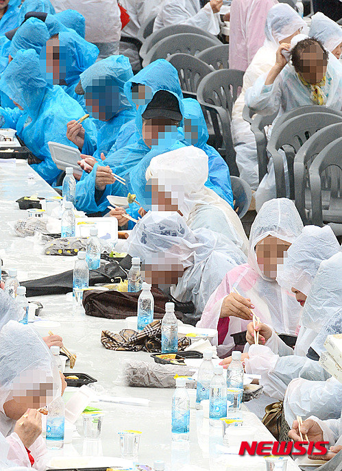 ▲ 지난 6일 오전 서울 용산가족공원 제2광장에서 서울시 주최로 열린 제44회 어버이날 기념식에 참석한 어르신들이 비를 맞으며 도시락을 먹고 있다. ⓒ뉴시스