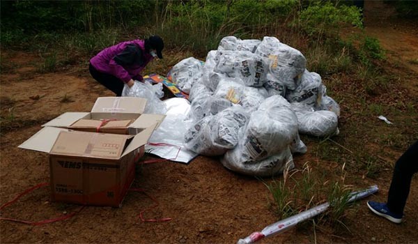 ▲ 대북전단 30만 장과 함께 북한 주민들에게 날려보낼 1달러 지폐, USB, SD카드, DVD, 소책자 등을 점검하는 자유북한운동연합 회원. ⓒ자유북한운동연합 제공