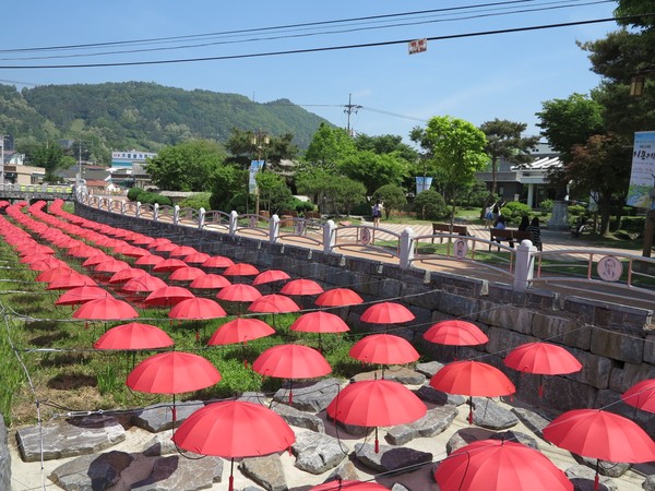 ▲ 정지용 문학관 앞 실개천에 전시한 우산등.ⓒ옥천군