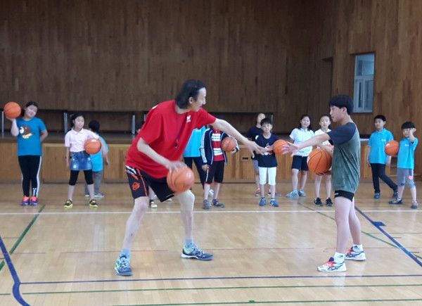 ▲ 전 프로 한기범 농구선수가 학생들에게 농구 드리블 방법을 가르쳐 주고 있다.ⓒ단양교육지원청