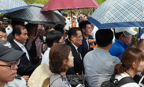 ▲ 국민의당 박지원 원내대표가 23일 경남 김해 봉하마을에서 폴리스라인에 의지해 우산을 받쳐들고 추도식장을 빠져나가고 있다. ⓒ김해(경남)=뉴데일리 정상윤 기자