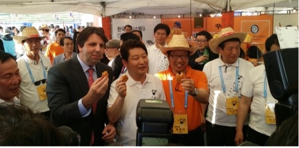 ▲ 땅땅치킨 옥광세 대표(왼쪽 중간 세번째)가 지난 해 열린 대구 치맥페스티벌에서 주한 리퍼트 대사와 권영진 대구시장과 땅땅치킨을 먹으며 기념촬영을 하고 있다.ⓒ대구시 제공