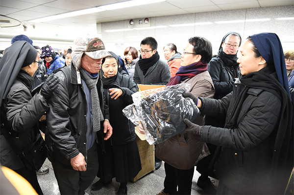 ▲ 꽃동네가 지난해 연말 서울 지하철 역에서 노숙인들에게 잠바를 나눠주고 있다.ⓒ꽃동네 홈페이지 캡처