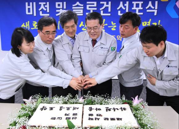 이성희 경남기업 대표(왼쪽에서 네번째)와 직원들이 새로운 비전 선포를 기념해 축하떡을 자르고 있다.ⓒ경남기업