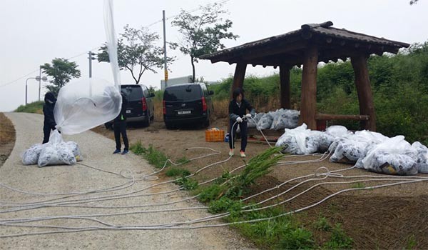 ▲ 대북전단을 살포하기 직전 전단 등의 물품이 든 꾸러미와 대형 애드벌룬을 연결하는 자유북한운동연합 관계자들. ⓒ자유북한운동연합 제공