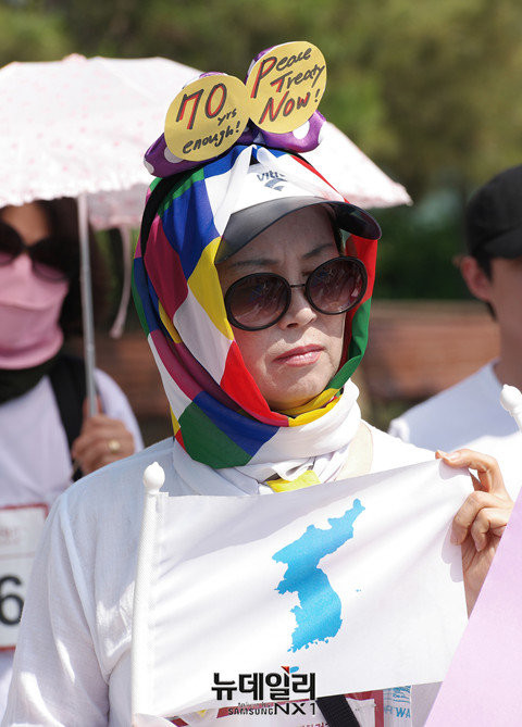 ▲ '2016 여성평화걷기'행사에 참여한 한 여성이 한반도기를 들고 있다. ⓒ뉴데일리 정상윤 기자