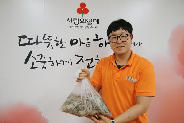 ▲ 서부종합사회복지관 조종래사회복지사와 1박스에 들어있는 낙지(생물).ⓒ충북공동모금회