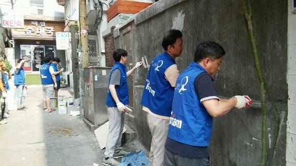 ▲ 현대로템 직원들이 10일 서울역 쪽방촌에서 낙후된 골목길 외벽에 페인트 칠하기 봉사활동을 펼치고 있다.ⓒ현대로템
