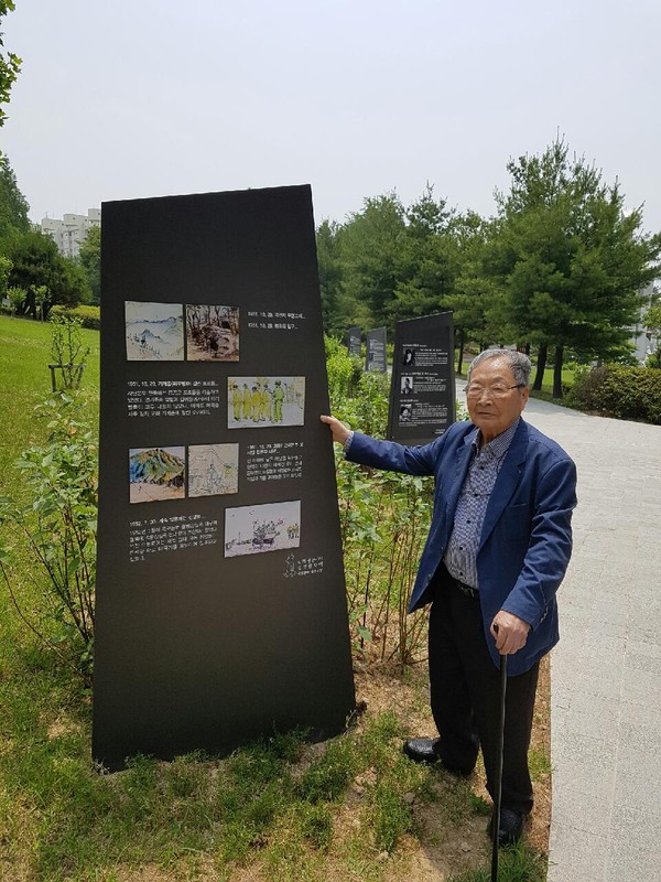 ▲ '고바우' 만화가 김성환 화백이 자신의 '6.25 전쟁 스케치가 전시된 수원 예술공원에서 작품 앞에 섰다.