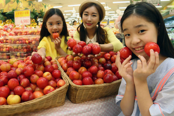 ▲ 11일 오전 서울 한강로 이마트 용산점에서 모델과 아이들이 새콤달콤한 맛을 자랑하는 대석자두를 선보이고 있다. ⓒ이마트