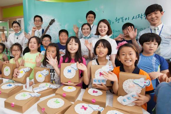 ▲ 하늘사랑 영어교실에 참여한 대한항공 직원 및 초등학생들이 행복나눔 도시락을 받고 기념 촬영을 하고 있는 모습.ⓒ대한항공