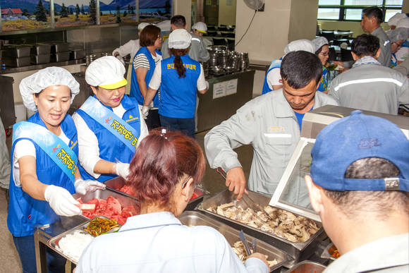 ▲ 현대삼호중공업 직원 부인들로 구성된 주부대학 동창회원들이 15일 초복(17일)을 앞두고 회사 식당에서 남편들을 응원하기 위해 삼계탕 배식에 나섰다.ⓒ현대삼호중공업