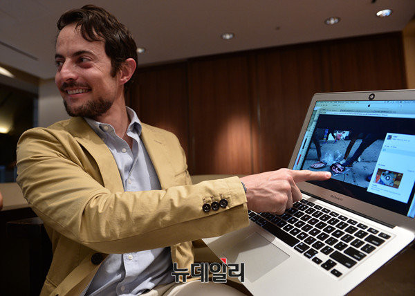 ▲ 과거 美뉴욕의 엠파이어 스테이트 빌딩 앞까지 왔던 한국 시위대가 자신의 얼굴사진을 밟는 모습을 찍은 사진을 보여주는 토르 할보르센 HRF 대표. ⓒ정상윤 뉴데일리 기자