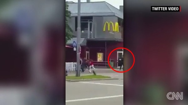 ▲ 22일(현지시간) 오후 5시 52분쯤 바이에른州 주도 뮌헨 북부에 위치한 '올림피아 쇼핑센터'의 패스트푸드점 '맥도널드' 앞에서 검은 옷을 입은 남성 1명이 시민들을 향해 무차별 총격을 가했다. 이번 사건으로 용의자를 포함해 총 10명이 사망했다. 사진은 총성이 발생한 후 (빨간원)용의자로 추정되는 인물 주변에서 달아나고 있는 시민들의 모습.ⓒ美CNN 중계영상 캡쳐