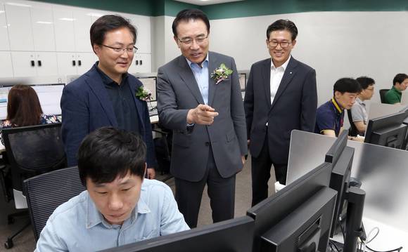 ▲ 서울시 강남구 역삼동에 위치한 스마트워킹 센터(신한 도곡중앙지점 1층)에서 조용병 신한은행장(사진 가운데)과 유주선 노동조합 위원장(사진 왼쪽)이 스마트워킹센터 내 사무공간을 둘러보는 모습 .ⓒ신한은행