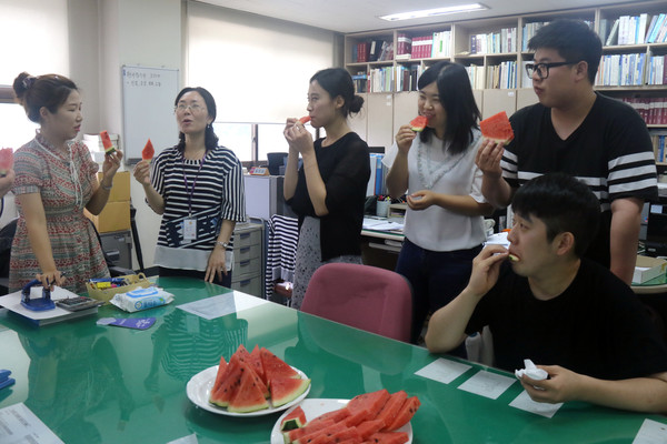 ▲ 충북대 교직원들이 27일 복놀이 음식으로 수박을 먹고 있다.ⓒ충북대