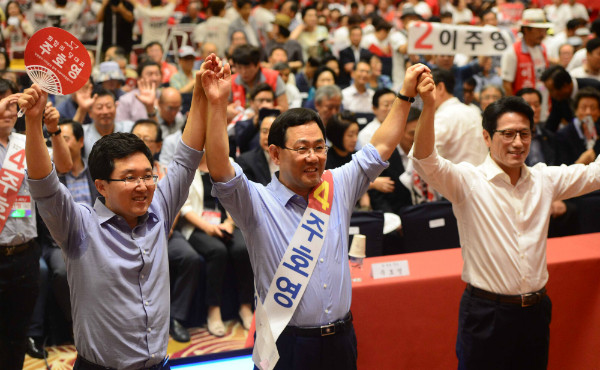 ▲ 전날 단일화 여론조사에서 패했던 새누리당 정병국 의원이 6일 수도권 합동연설회가 열린 서울 양재동 더케이호텔에 나타나 김용태 의원과 함께 단일후보 주호영 의원의 손을 좌우에서 치켜들고 있다. ⓒ뉴시스 사진DB