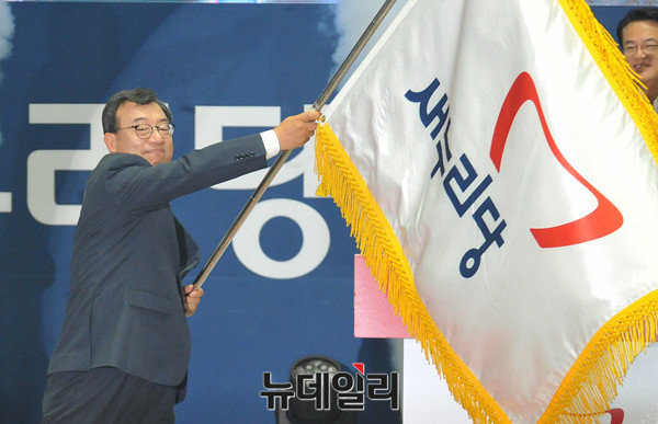 ▲ 새누리당 이정현 의원이 9일 전당대회에서 당대표로 선출된 직후 김희옥 전 비상대책위원장으로부터 넘겨받은 새누리당 당기를 힘차게 흔들고 있다. ⓒ뉴데일리 이종현 기자