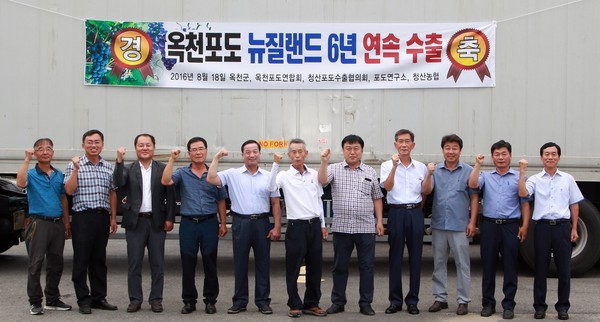 ▲ 지난 18일 충북 옥천 청산면 판수리 수출 선과장에서 뉴질랜드행 수출포도 10톤을 컨테이너에 실은 후 관계자들(군수 옆 흰색 옷이 김완수 청산포도수출협의장)이 기념촬영하고 있다.ⓒ옥천군