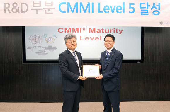 ▲ 이승주 CMMI 선임심사원(왼쪽)이 양성철 LIG넥스원 연구기획담당(오른쪽)에게 CMMI의 최고 단계인 레벨5를 4회 연속 인증서를 전달하고 있다.ⓒLIG넥스원