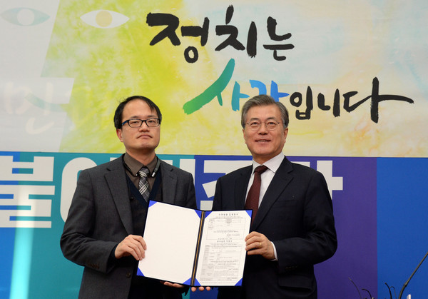 ▲ 문재인 더불어민주당 대표가 지난 1월25일 오후 국회 대표실에서 거리의 변호사로 불리는 박주민 민주사회를위한변호사모임 사무차장영입 기자회견에 참석해 입당원서를 들고 포즈를 취하고 있다.ⓒ뉴시스