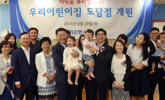 ▲ 29일 서울 중구 소공로 우리은행 본점에서 열린 우리어린이집 도담점 개원식에서, 이광구 은행장(사진 앞줄 왼쪽에서 7번째)이 박원춘 노동조합 위원장(사진 앞줄 왼쪽에서 4번째) 및 어린이, 학부모 등과 함께 기념촬영을 하고 있는 모습. ⓒ우리은행 제공